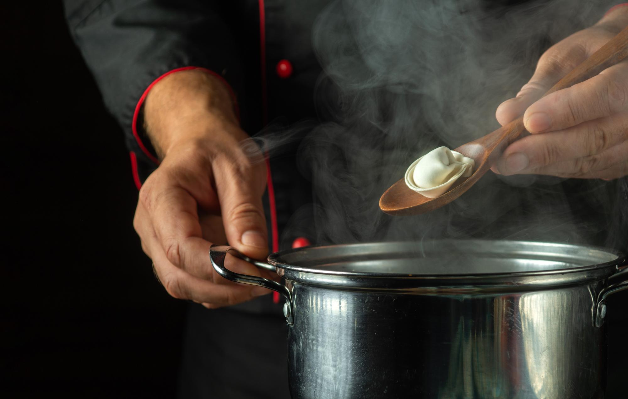 Close-up of chef's hands preparing sauce